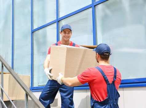 Professional movers handling belongings with safety measures in place