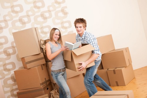Packed household boxes and furniture ready for removal from a Bow flat